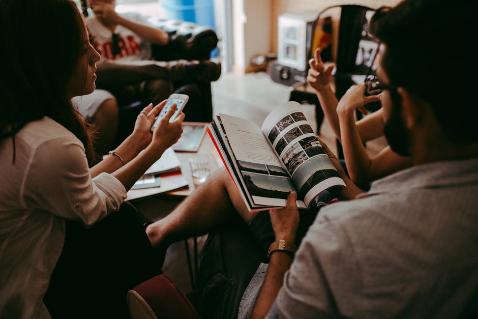 Casual group discussion with people reading a magazine and interacting indoors.